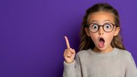 Surprised Caucasian girl in round glasses and gray sweater pointing up with index finger against purple background, expressing excitement and wonder.