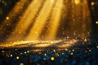 Magical golden light rays shine through darkness with glowing bokeh particles and sparkles scattered across dark textured surface creating ethereal atmosphere.