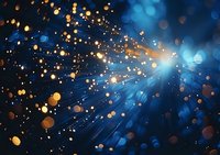 Magical glowing particles and light rays burst through deep blue space background with golden bokeh effect creating ethereal cosmic atmosphere.