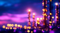 Glowing industrial lights create magical bokeh effect against dramatic purple and blue twilight sky, illuminating modern factory or refinery structures.