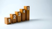 Wooden blocks numbered one through five arranged in ascending order on white background, representing growth, progress, steps, and business development concepts.
