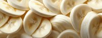 Fresh sliced bananas in close-up view, showing creamy white flesh with natural texture and subtle brown spots, ready for culinary use.