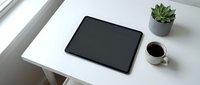 Modern workspace with black tablet, coffee cup and succulent plant on clean white desk for business productivity and digital lifestyle.