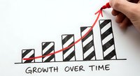 Hand drawing red arrow on ascending bar chart showing business growth over time concept for success and progress analytics.