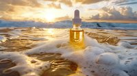 Essential oil glass dropper bottle on ocean foam at golden sunset, sunlight streaming through dramatic clouds over calm sea waves, wellness concept.