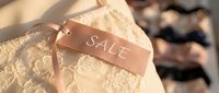 Elegant lace lingerie with a satin sale tag, soft beige tones, blurred boutique background, perfect for fashion retail and shopping promotions.