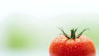 Fresh ripe red strawberry with green leaves on soft blurred background for healthy eating and organic food concepts.
