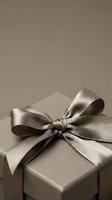 Elegant taupe gift box with a luxurious satin ribbon bow on a neutral background, evoking sophistication for holiday, wedding, or premium gifting concepts.