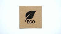 Eco-friendly cardboard label with green leaf symbol and ECO text for sustainable packaging and environmental branding on white background.