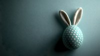 Minimalist Easter egg decorated with bunny ears and polka dot pattern in mint green and white colors against dark background with dramatic lighting.