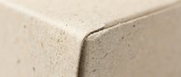 Close-up of beige foam insulation material corner showing porous texture and density for construction and building energy efficiency applications.