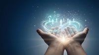 Human hands cupping glowing holographic people icons with connecting network lines against blue background for business teamwork concepts.