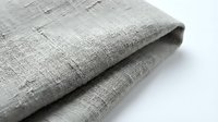 Gray linen fabric with natural texture folded on white background. Organic cotton textile material for sewing, crafts and home decor projects.
