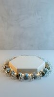 Hexagonal white podium surrounded by decorative blue and white spheres with dried flowers for product display and presentation.