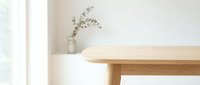 Minimalist wooden table corner with ceramic vase and dried eucalyptus branch in bright modern interior with natural lighting for home decor concepts.