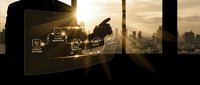 Professional businessman using futuristic holographic interface technology in modern office with city skyline background during golden hour sunset.
