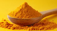 Ground turmeric powder heaped in wooden spoon against vibrant yellow background, scattered spice particles create texture and depth for culinary and wellness concepts.