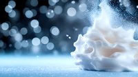 Delicate white foam or cream swirl against blue bokeh background with sparkling particles and soft focus lighting effects creates dreamy atmosphere.