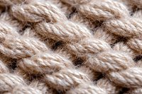 Close-up macro view of beige knitted wool texture showing detailed yarn pattern and fiber structure. Natural material background for fashion and craft designs.