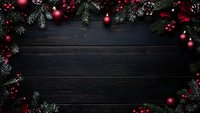 Christmas frame with red ornaments and pine branches on dark wooden background, creating festive holiday border with copy space.