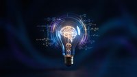 Glowing light bulb with brain inside surrounded by digital circuits and data streams on dark blue background representing innovation and artificial intelligence.