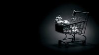 Shopping cart filled with shiny coins and dollar signs on dark background, representing retail spending, financial transactions, commerce, and consumer purchasing power for business concepts.