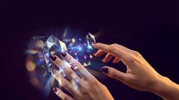 Hands holding glowing digital device with holographic data visualization and light particles, representing technology, communication, and digital innovation for business applications.