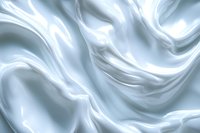 Smooth flowing white silk fabric with gentle folds and waves creates elegant abstract pattern in soft light blue tones, suitable for luxury design backgrounds.