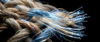 Fiber optic cables with glowing blue light transmission merging with natural rope fibers on black background for technology and communication concepts.