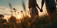 Romantic couple holding hands walking through golden wheat field at sunset with warm sunlight creating dreamy atmosphere for love and relationship concepts.