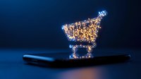 Shopping cart made of glowing particles floating above smartphone on dark blue background, modern e-commerce and digital retail concept visualization.