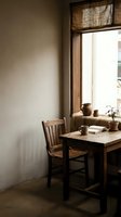 Cozy rustic dining nook with wooden chair and table by window featuring natural bamboo blinds and warm sunlight streaming through for home decor.