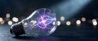 Glowing lightbulb with purple electric plasma filament on dark surface, symbolizing innovation, energy, and creative ideas for technology and business concepts.