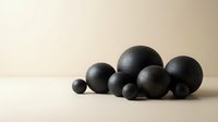 Black spheres of various sizes arranged on neutral beige surface creating minimalist geometric composition for modern interior design and contemporary decor.