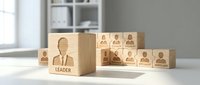 Wooden blocks with engraved business people icons representing team leadership and organizational hierarchy concepts for corporate training materials.