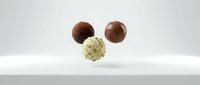Assorted chocolate truffles with cocoa and white coating displayed on neutral surface for confectionery, bakery, and food styling projects.