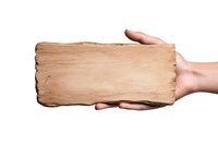 Hands holding weathered wooden plank sign with rough texture against white background, isolated mockup for rustic design elements and signage.