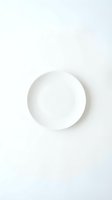 Empty white ceramic plate on clean white background for food photography and kitchen design projects.