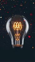 Vintage Edison light bulb glowing with warm filament against dark background with colorful bokeh lights for creative design projects.