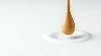 Golden liquid drop suspended above white rippled surface, symbolizing luxury skincare, cosmetics, or premium oil product concepts.