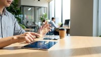 Professional businesswoman using digital tablet with holographic interface technology in modern office workspace for innovative business solutions.