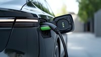 Charging port of modern electric vehicle with connected power cable, close-up view showing sleek design details and green energy technology in urban setting.