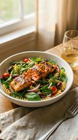 Grilled salmon fillet with pasta salad, fresh herbs and vegetables in white bowl on wooden table with wine glass for healthy dining and restaurant menu.