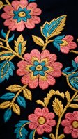 Colorful floral embroidery on black fabric featuring pink flowers with turquoise centers and golden leaves in traditional decorative needlework style.