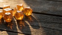 Orange translucent gaming dice scattered on rustic wooden surface with dramatic lighting and shadows creating atmospheric tabletop gaming scene.