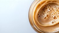Fresh espresso coffee with rich crema foam in glass cup on white background, perfect for cafe menus, morning beverage concepts and coffee shop marketing materials.