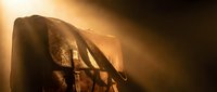 Ancient warrior helmet with dramatic golden lighting and atmospheric smoke effects for historical and fantasy themed projects.