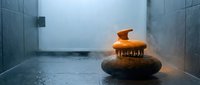 Zen spa stones with burning candle in modern bathroom creating peaceful meditation atmosphere for wellness and relaxation rituals.