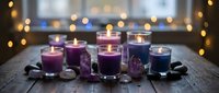 Purple scented candles in glass holders with crystals on rustic wooden table creating cozy atmosphere with warm bokeh lights background for relaxation.