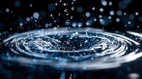 Macro photography of water ripples with droplets creating concentric circles on dark surface. Dynamic splash captured with bokeh effect in blue tones.